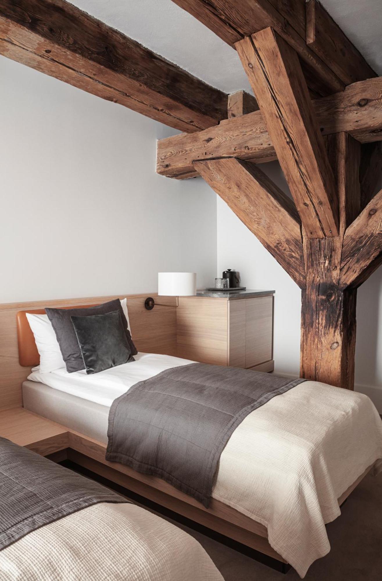 Copenhagen Admiral Hotel Esterno foto The photo shows a cozy bedroom featuring a single bed with a light-colored bedspread and a couple of decorative pillows. Next to the bed is a wooden bedside table with a lamp. There is also a compact cabinet that likely houses a coffee maker, positio
